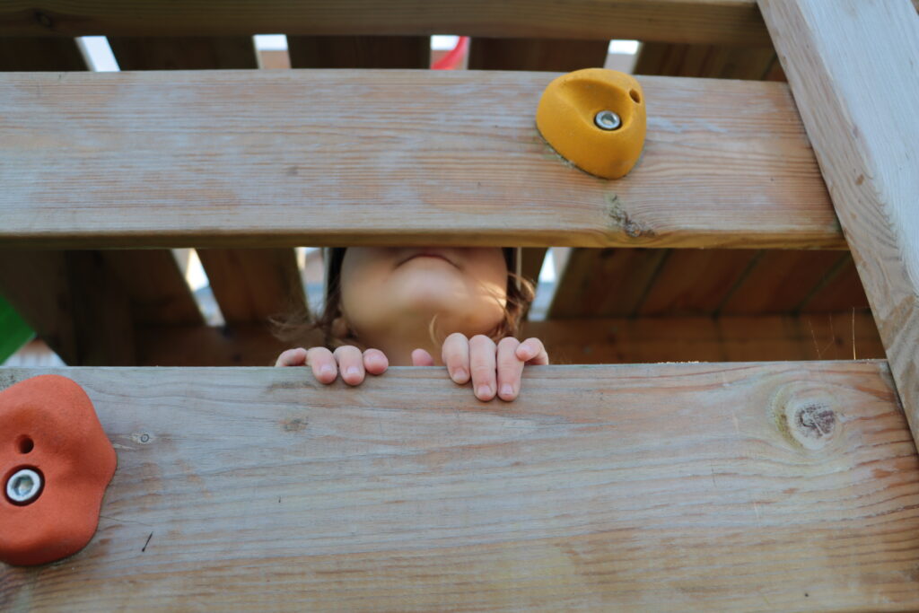 Kind versteckt sich im Spielhaus