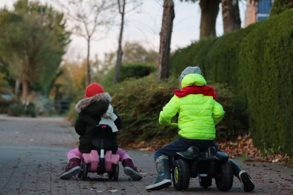 Zwei Kinder fahren auf Rutschautos